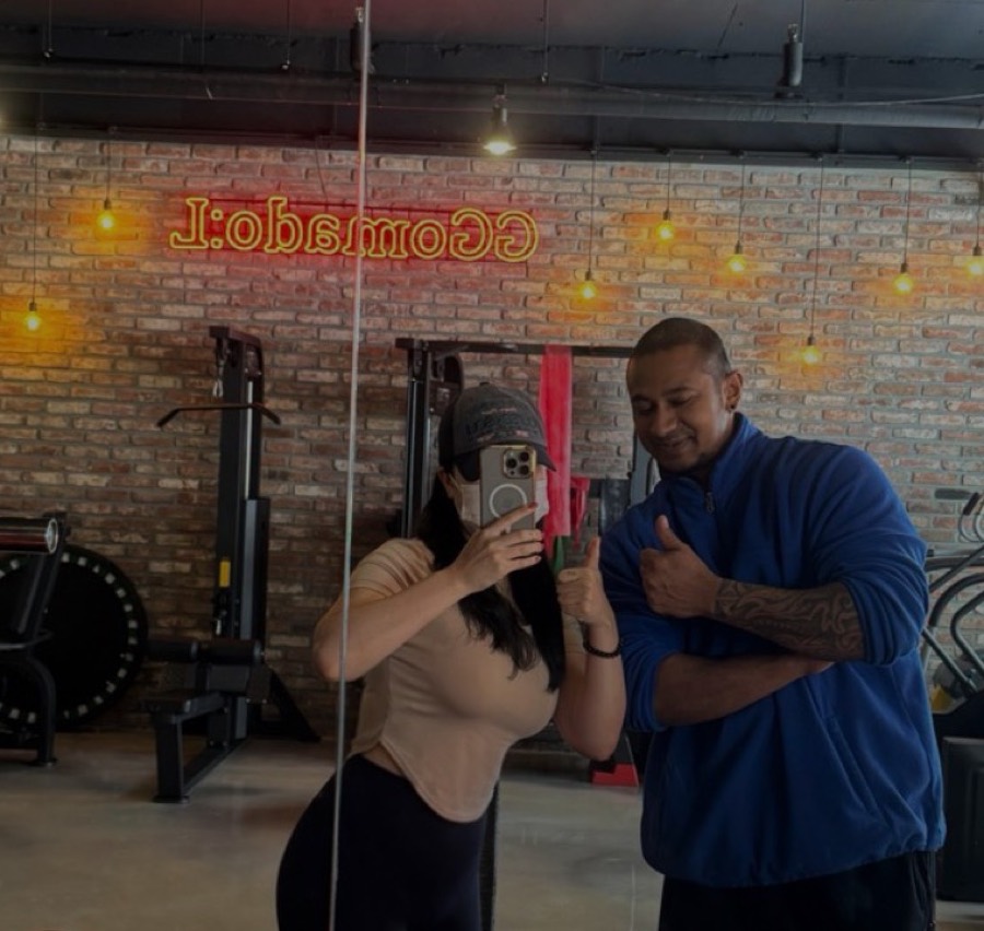 Coach Vinzy with the client in the gym mirror