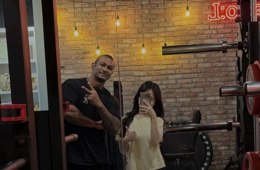 Coach Vinzy with the client in the gym mirror